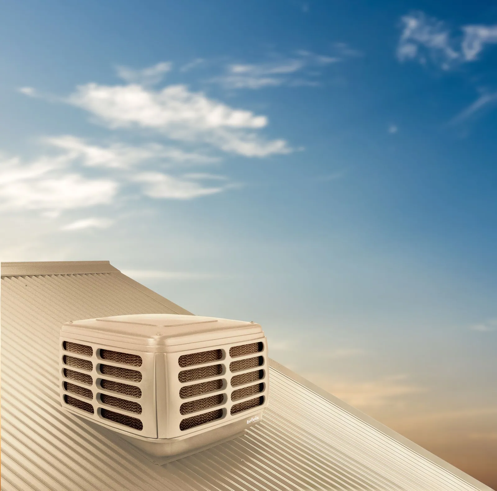 Brivis Advance evaporative cooler in beige on a tiled roof with clouds behind