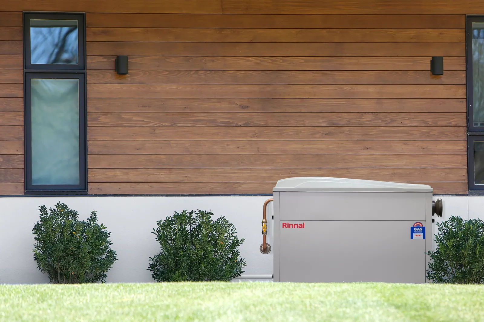 Rinnai external gas ducted heater installed against the timber-clad side wall of a home