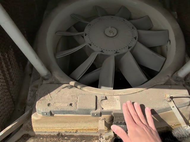 Checking the fan and pump inside an evaporative cooler on a roof
